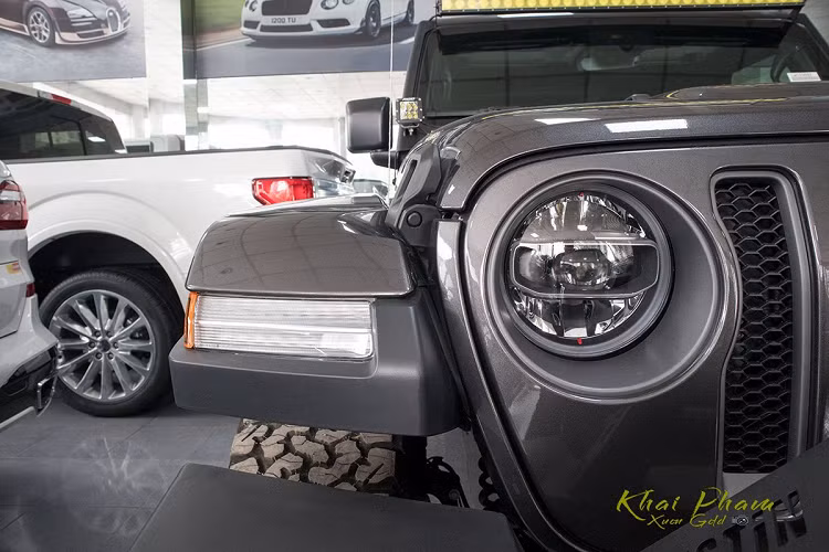 Đầu xe địa hình Jeep Wrangler Rubicon 2020 đầu tiên về Việt Nam cứng cáp nhờ cản trước tách biệt sơn đen sần cùng móc kéo và cuộn tời chuyên phục vụ việc Off-Road. Phần cản trước này còn được trang bị dàn đèn LED hỗ trợ việc di chuyển ở điều kiện thời tiết xấu.