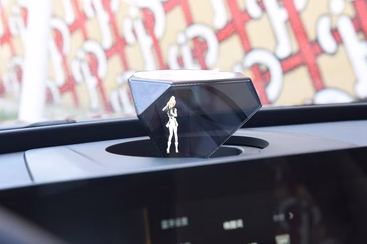 Trong ảnh, chúng ta thấy trợ lý này giống như một “em gái hoạt hình Nhật Bản” dễ thương, nhưng thực tế thì người dùng có thể lựa chọn thay đổi sang nhiều hình tượng khác nếu muốn. Bên cạnh đó, mẫu SUV điện này có một hệ thống âm thanh được thiết kế bởi công ty Đan Mạch Jamo.