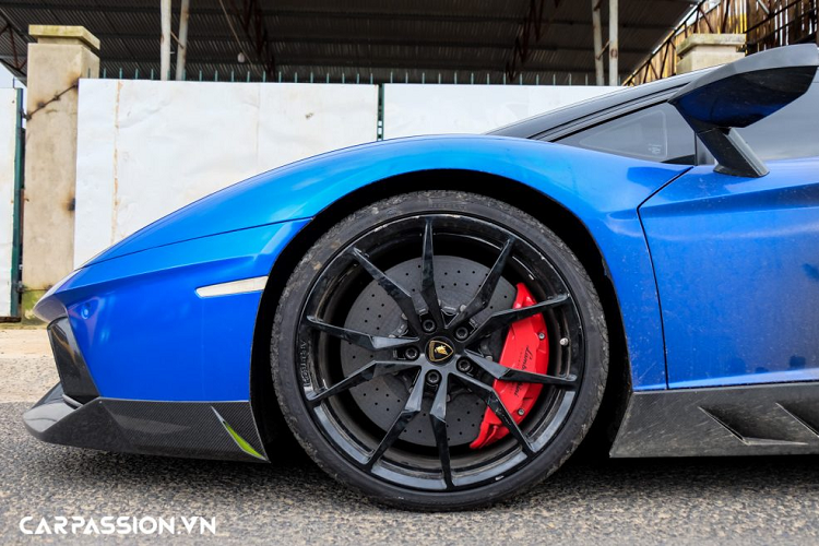 “Siêu bò” Lamborghini Aventador LP700-4 này sở hữu bộ mâm đa chấu sơn đen bóng. Ẩn phía sau là hệ thống phanh đĩa hiệu năng cao gồm cùm phanh sơn đỏ làm điểm nhấn và đĩa phanh gốm carbon có khả năng chịu nhiệt tốt. Bộ mâm có kích thước cho bánh trước/sau lần lượt là 20 và 21 inch, đi kèm với bộ lốp Pirelli P Zero được trang bị tiêu chuẩn theo xe với thông số 255/30/R20 (bánh trước) và 355/25/R21 (bánh sau), trong đó phần lốp sau của xe có kích thước gần như lớn nhất ở phân khúc siêu xe hiện nay.