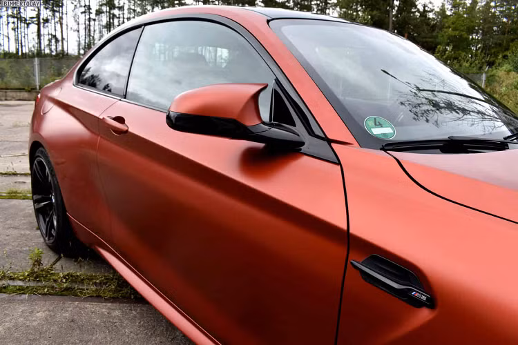 Nhìn từ phía trước, màu sơn Frozen Sunset Orange làm nổi bật các hình dáng và đường nét hung hãn của cản trước một cách hoàn hảo, làm tăng thêm vẻ uy nghi cho chiếc xe. Màu sơn cũng loại bỏ các điểm nhấn màu đen khác nhau của M2 Competition, chẳng hạn như lưới tản nhiệt hình quả thận đặc trưng góc cạnh, trong khi bộ la-zăng phong cách 437 M 5 chấu kép hoàn thiện bên ngoài.