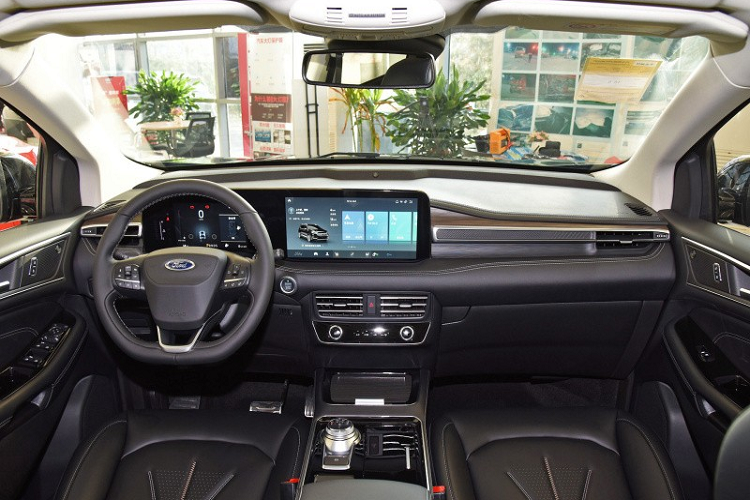 Trên cụm điều khiển trung tâm của mẫu xe Mỹ này không có cần số truyền thống, thay vào đó là núm xoay chọn số. Thêm vào đó là ngăn chứa đồ có nắp che, tích hợp khay sạc điện thoại thông minh không dây và cổng USB... Theo hãng Ford, khoảng duỗi chân cho hành khách ngồi trên hàng ghế thứ 2 của Edge Plus 2021 đã được tăng lên.
