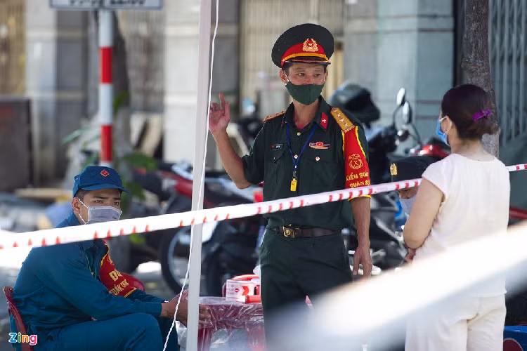 Xóm chạy thận ở con hẻm cạnh Bệnh viện Đà Nẵng có 25 người, trong đó 22 người đang chạy thận và 3 người thân chăm sóc. Sau khi phong tỏa, bệnh viện đã hỗ trợ xe đưa đón người dân chạy thận và cách ly ở khách sạn tại quận Sơn Trà. Trong ảnh, một người mẹ đang năn nỉ cảnh sát cho vào bệnh viện chăm con chạy thận. 