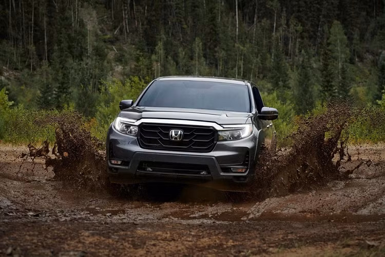 Điểm nhấn của Honda Ridgeline 2021 nằm ở nắp ca-pô mới với đường dập gân nổi bật. Tiếp đến là chắn bùn trước thiết kế mới, hệ thống đèn pha LED nâng cấp và lưới tản nhiệt thẳng đứng hơn. Chưa hết, xe còn có nẹp dày dặn nối giữa 2 đèn pha, được sơn màu đen bóng ở bản Sport và Black Edition. Trong khi đó, ở bản RTL và RTL-E, nẹp này được mạ crôm sáng bóng. Ngoài ra, hãng Honda còn bổ sung cản trước mới, tích hợp khe gió cỡ lớn ở hai bên góc, và tấm ốp gầm bên dưới.