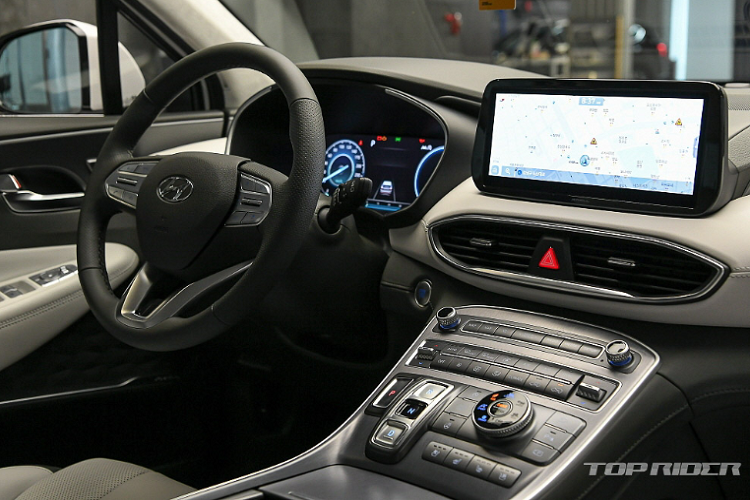 SantaFe 2021 nâng cấp mới nay cũng có một bộ mâm hoa mai 20 inch mới, cùng một số tùy chọn mâm nhỏ hơn khác. Thân xe được dập nổi kết hợp chi tiết trang trí bạc, liền mạch từ đầu qua thân đến đuôi xe. Nội thất Santa Fe mới được nâng cấp mạnh. Chính giữa là màn hình thông tin giải trí cảm ứng 10,25 inch, cạnh đó là màn hình cụm đồng hồ kỹ thuật số 12,3 inch.