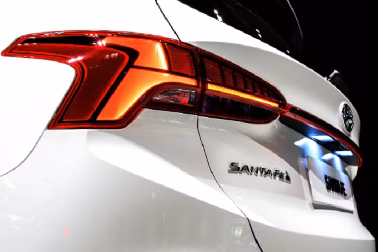 Nan lưới SantaFe trông thanh lịch và ấn tượng hơn trước. 2 phiên bản SantaFe 2021 là Standard và Luxuxy trước hết sẽ khác nhau ở cách thiết kế lưới tản nhiệt. Sau xe, cụm đèn hậu cũng bắt mắt hơn khi thiết kế chữ T và nối liền 2 đèn bằng dải LED mỏng bắt ngang thân. Cản sau thay đổi trông cứng cáp hơn.