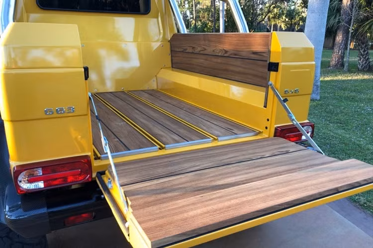 Vẻ đẹp hầm hố của "quái vật 6 chân" Mercedes-Benz G63 AMG 6x6 độc nhất Việt Nam nhìn từ phía sau. Chiếc xe này còn được trang bị hệ thống ống xả độ của hãng Akrapovic có giá lên đến 395 triệu đồng. Thảm sàn cho khoang hành lý phía sau trên "quái vật 6 chân" Mercedes-Benz G63 AMG 6x6 độc nhất vô nhị tại Việt Nam được ốp gỗ tếch.