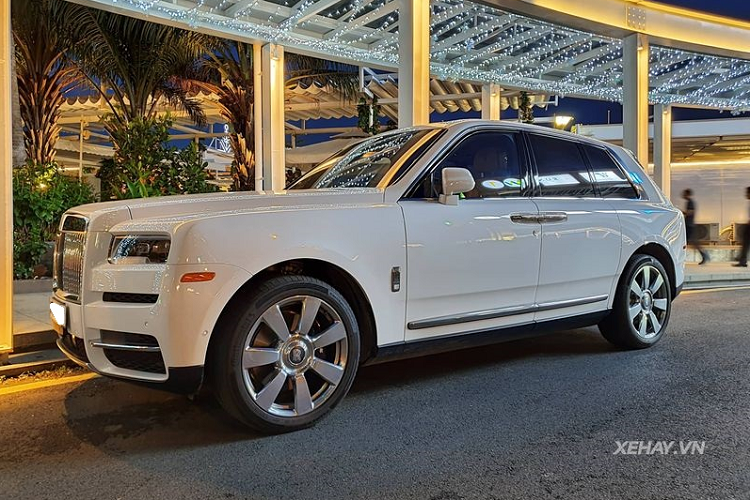 Sức hút của chiếc Rolls-Royce Cullinan hạng sang này đến từ màu sơn trắng English White nhẹ nhàng nhưng rất thanh lịch, tạo điểm nhấn cho xe là đường coachline màu cam Mandarin chạy dọc thân xe cùng rất nhiều chi tiết crôm sáng loáng như cụm lưới tản nhiệt, viền líp trước, tay nắm cửa, đường lằn chạy bên dưới cửa xe, ốp ống xả, hốc gió...
