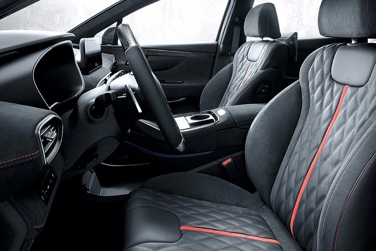 Với gói nâng cấp N-Performance, nội thất của Hyundai SantaFe thay đổi hoàn toàn, từ thiết kế sang trọng cao cấp chuyển sang phong cách thể thao mạnh mẽ. Cabin được bọc da Alcantara khâu chỉ đỏ đi cùng nhiều chi tiết trang trí ốp carbon ở bảng tablo, vô-lăng, viền cửa hay phía sau lưng ghế.