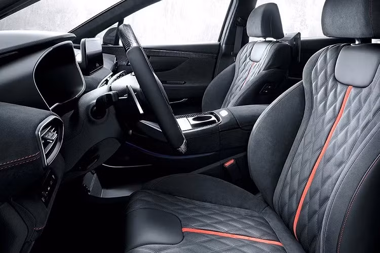 Với gói nâng cấp N-Performance, nội thất của Hyundai SantaFe thay đổi hoàn toàn, từ thiết kế sang trọng cao cấp chuyển sang phong cách thể thao mạnh mẽ. Cabin được bọc da Alcantara khâu chỉ đỏ đi cùng nhiều chi tiết trang trí ốp carbon ở bảng tablo, vô-lăng, viền cửa hay phía sau lưng ghế.