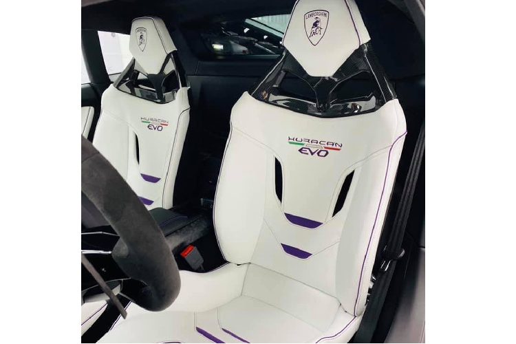 Bước vào bên trong, khoang lái tiếp tục tạo nên sự ấn tượng với màu trắng làm chủ đạo. Trên Huracán EVO, Lamborghini đã sử dụng bộ ghế ngồi thể thao với thiết kế mới, đẹp mắt hơn rất nhiều so với mẫu xe trước đây và dĩ nhiên là ốp lưng ghế bằng sợi carbon. Nội thất được bọc da màu trắng Bianco Monocerus và đen Nero Ade phối theo kiểu màu kép Bicolor Sportivo. Cùng với đó là các đường chỉ khâu, đường viền màu tím Viola Acutus được thêm thắt theo phong cách Finitura EVO.