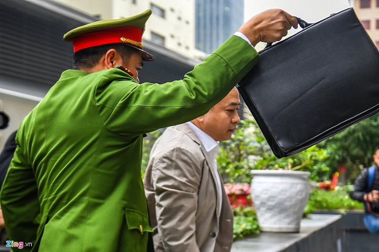 Vũ là 1 trong số 3 bị cáo bị tạm giam được dẫn giải đến tòa bằng xe thùng. Cựu Chủ tịch Công ty CP Xây dựng Bắc Nam 79 mặc vest, quần âu sáng màu. 