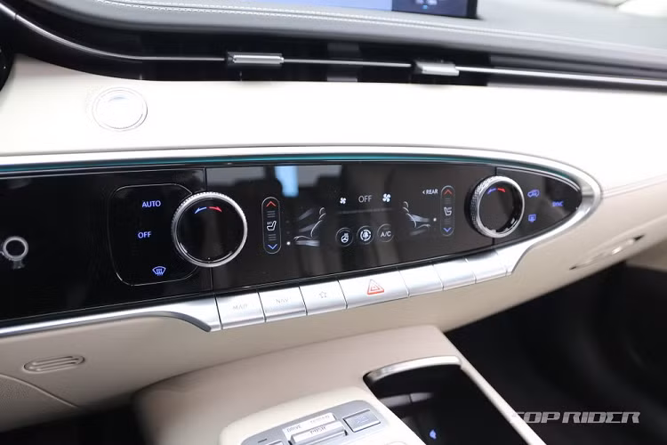 Bên trong mẫu SUV hạng sang cỡ trung này xuất hiện mặt táp-lô có thiết kế khác biệt so với những người anh em còn lại. Theo đó, mặt táp-lô của Genesis GV70 2021 được thiết kế gọn gàng hơn, nhấn mạnh bằng đường viền đơn chạy từ mặt cửa đến cửa gió điều hòa và bảng đồng hồ.