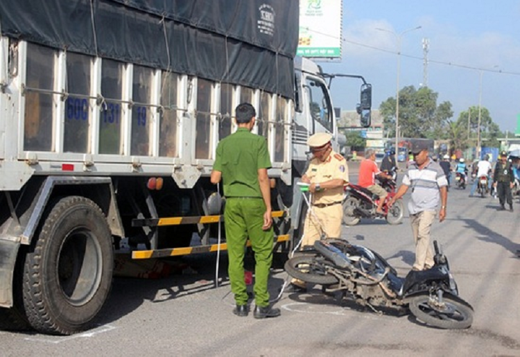 Xe tai mat lai tong xe may dang cho den do khien mot phu nu thiet mang