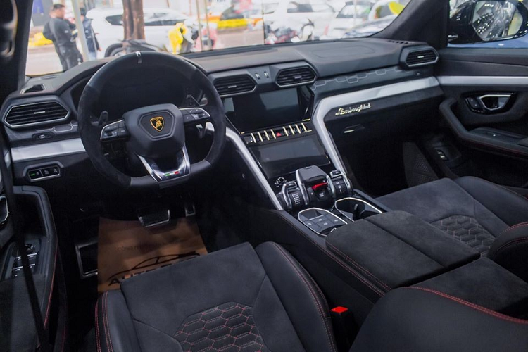 Tiến vào bên trong khoang lái, nội thất siêu SUV Lamborghini Urus của chồng siêu mẫu Ngọc Thạch có ghế ngồi bọc da Alcantara màu đen đi cùng chỉ màu đỏ, hai bên hông vô lăng cũng được bọc da Alcantara.