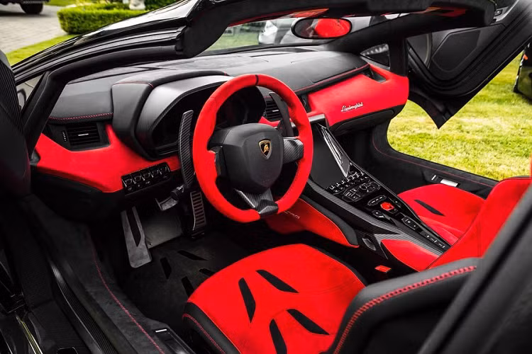 Bên trong chiếc Centenario Roadster nổi bật với màu đỏ của chất liệu da Alcantara trên ghế ngồi, bảng táp-lô, vô-lăng... Da Alcantara màu đen cũng được dùng ở một số chi tiết giúp tăng thêm sự nổi bật cho khoang nội thất.