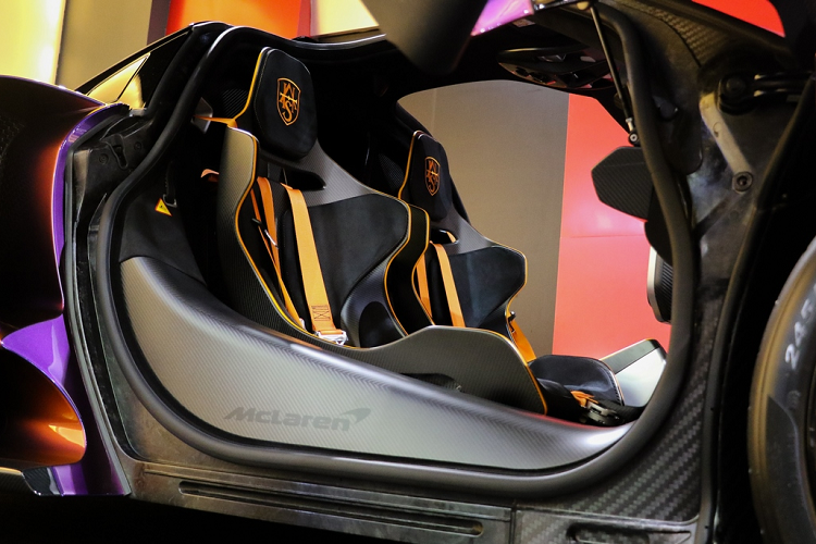 Chiếc Mclaren Senna MSO này sở hữu khoang lái được bọc da Alcantara màu đen với những đường nét tương phản, thủy lực đỡ cửa màu cam nổi bật. Sợi carbon cũng được sử dụng rộng rãi bên trong khoang lái, màn hình lật được trang bị, các nút điều chỉnh hộp số được gắn chặt với ghế lái. 