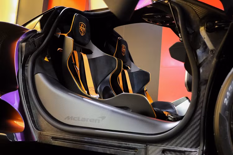 Chiếc Mclaren Senna MSO này sở hữu khoang lái được bọc da Alcantara màu đen với những đường nét tương phản, thủy lực đỡ cửa màu cam nổi bật. Sợi carbon cũng được sử dụng rộng rãi bên trong khoang lái, màn hình lật được trang bị, các nút điều chỉnh hộp số được gắn chặt với ghế lái. 