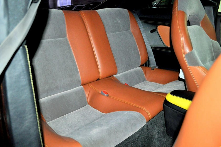 Đáng tiếc là những chi tiết này lại chẳng giống Lexus LC 500 chút nào. Bên trong chiếc Lexus LC 500 "nhái" này, chữ "Celica" vẫn còn nguyên trên ốp bậc cửa. Phần lớn nội thất đều được bọc da phối 2 màu đen - cam tương phản. Riêng trên ghế còn còn khu vực bọc nỉ màu xám lông chuột khá khó hiểu.