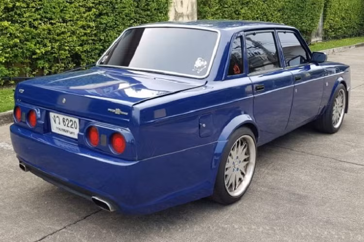 Vòng ra phía sau, chúng ta sẽ tìm thấy cụm đèn hậu được bê nguyên từ mẫu xe thể thao Nhật Bản Nissan Skyline thế hệ R32 sản xuất từ năm 1989 - 1994. Bên dưới là 2 ống xả hình chữ nhật và cản sau đầy đặn. Cuối cùng, chiếc Rolls-Royce Phantom "nhái" này được sơn màu xanh dương. Bên trong chiếc Volvo 240 "nhái" Rolls-Royce Phantom là nội thất "cổ lỗ sĩ" nhưng được bọc da màu đen phối chỉ đỏ tương phản. Ghế, mặt táp-lô và mặt cửa đều được phủ da khâu quả trám.