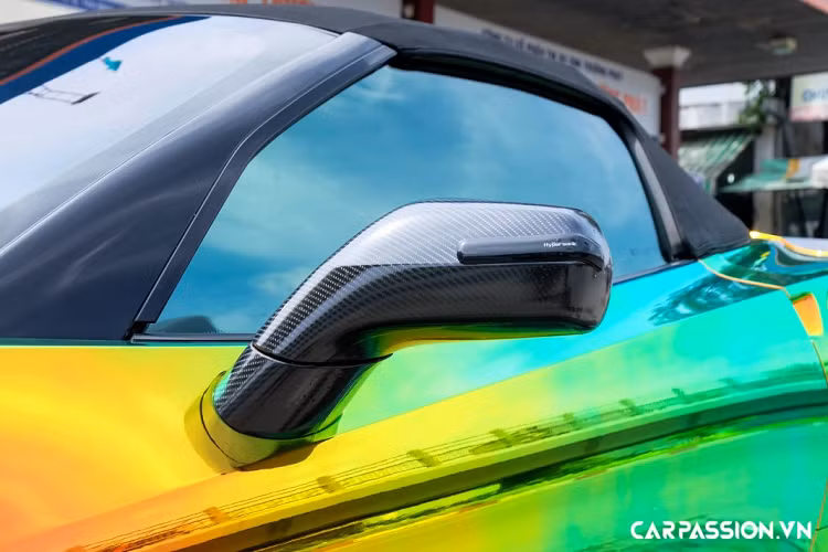 Được biết, xe đã được chủ nhân “tân trang” diện mạo bằng phương pháp dán decal, lớp áo mới mang phong cách tán sắc và có khả năng chuyển màu theo góc nhìn, thu hút rất nhiều ánh mắt hiếu kì của người đi đường. Bên cạnh đó, một số chi tiết khác ở phần ngoại thất cũng được dán giả sợi carbon như : líp trước, líp gió hông, gương chiếu hậu, khe thoát khí trên nắp ca-pô, mâm xe, cánh gió và cản sau.