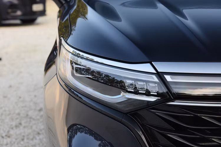 Nối liền với lưới tản nhiệt màu đen của Roewe iMax8 là cụm đèn pha LED thanh mảnh, được bao quanh bởi dải đèn LED định vị ban ngày. Chưa hết, cụm đèn pha còn được nối với nhau bằng một dải đèn thanh mảnh ở giữa, nằm ngay bên dưới nắp ca-pô.