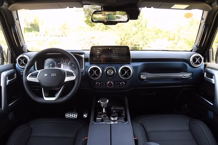 Giống như bản thường, BAIC BJ40 Tribute 2020 cũng được trang bị nội thất bọc da, bảng đồng hồ kỹ thuật số, màn hình thông tin giải trí 12,3 inch nằm độc lập, ghế trước chỉnh điện và phanh đỗ xe điện tử. Bên dưới màn hình trung tâm là 2 cửa gió điều hòa hình tròn và nút bấm khởi động máy.