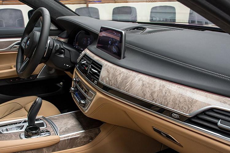 Tiến vào bên trong, nội thất của xe được bọc da màu Be Zagora Beige – một tùy chọn tiêu chuẩn trên 750Li. Tuy nhiên, điểm khác biệt trên khoang cabin này đến từ các thanh, nẹp gỗ bóng với tone màu sáng chạy ngang mặt taplo, tới các thanh cửa cũng như phủ kín khu vực điều khiển trung tâm.