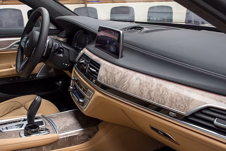Tiến vào bên trong, nội thất của xe được bọc da màu Be Zagora Beige – một tùy chọn tiêu chuẩn trên 750Li. Tuy nhiên, điểm khác biệt trên khoang cabin này đến từ các thanh, nẹp gỗ bóng với tone màu sáng chạy ngang mặt taplo, tới các thanh cửa cũng như phủ kín khu vực điều khiển trung tâm.