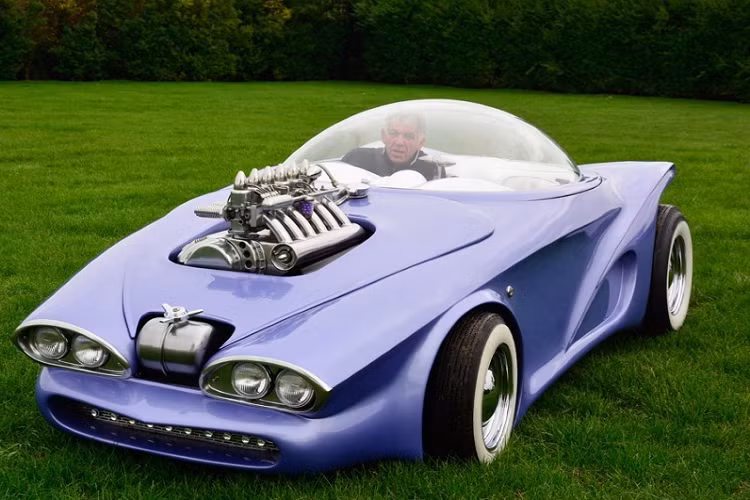 Nếu bạn đang tìm kiếm những chiếc xe độ vượt sức tưởng tượng, thiếu tính thực dụng nhưng ấn tượng về mặt thị giác ở Vương quốc Anh, vậy thì Paul Bacon là người đáng để xem qua. Dự án đầu tiên xứng đáng với lời tán dương kia của Paul, một chiếc xe bong bóng Cosmotron, là bằng chứng cho thấy trí tưởng tượng của anh ấy phong phú và hoang dại đến nhường nào, cùng với đó là kỹ năng chế tạo khéo tay ra làm sao.