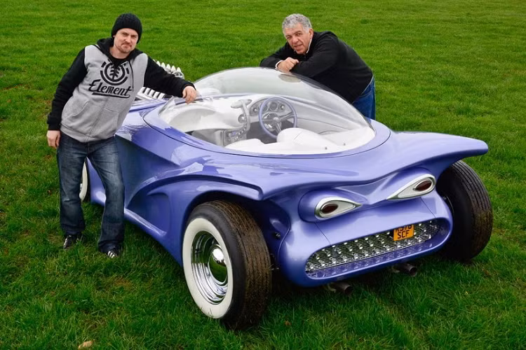 Cosmotron, hoặc gọi tắt là Cosmo, là dự án xe tự chế thứ hai trong sự nghiệp của Paul Bacon, và cho dù ra đời cách đây khá lâu, nó vẫn là một ví dụ tuyệt vời cho chuyện “phong cách hoàn hảo, tính năng tàm tạm”. Về bản chất, Cosmo độ từ BMW Z3 1998 với động cơ I6 dung tích 2.8 lít, nhưng bạn khó có thể nhìn ra điểm chung nào giữa BMW Z3 và chiếc xe bong bóng màu tím mộng mơ này.