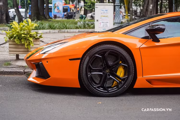 Tuy nhiên, một trong hai chiếc Lamborghini Aventador LP700-4 với màu sơn trắng mờ đó mới đây đã được “thay áo” với gam màu cam nổi bật. Màu cam mà chủ nhân của xe lựa chọn có phần tươi sáng và dịu hơn khi so với màu sơn Arancio Argos đặc trưng của dòng xe này. Sắc cam được sử dụng để bao phủ toàn bộ ngoại thất của xe và được tô điểm bằng đường kẻ sọc đặt lệch, chạy dài từ đầu đến hết đuôi xe. Một số chi tiết như ốp gương và logo Lamborghini phía sau cũng được dán đen.