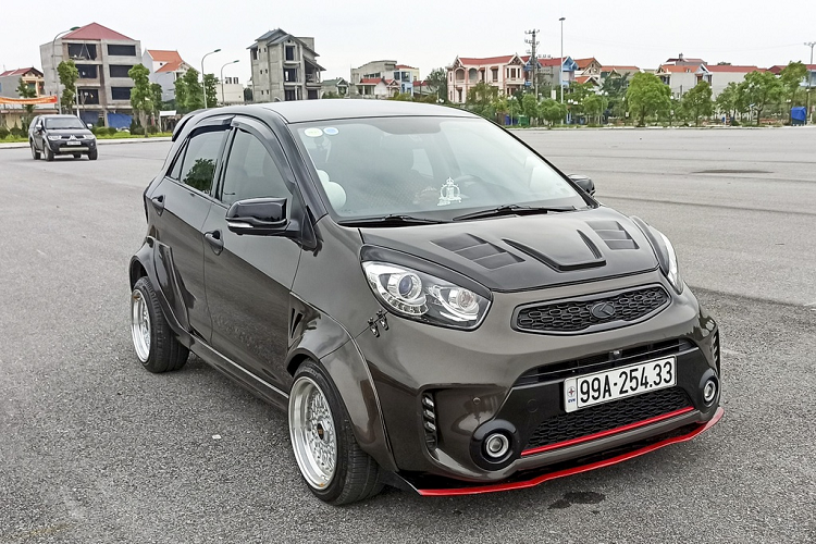 Chiếc Kia Morning độ lại với gói nâng cấp thân rộng này của một người chơi xe ở Bắc Ninh. Xe đã được thay đổi kích thước vành và lốp xe. Riêng phần hốc lốp được ốp thêm các tấm nhựa có tác dụng giảm độ cản gió và tăng tính thẩm mỹ cho xe.