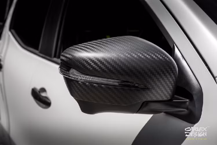 Gương chiếu hậu 2 bên được trang trí bằng các đường vân giả carbon tương phản với màu trắng chủ đạo của xe.