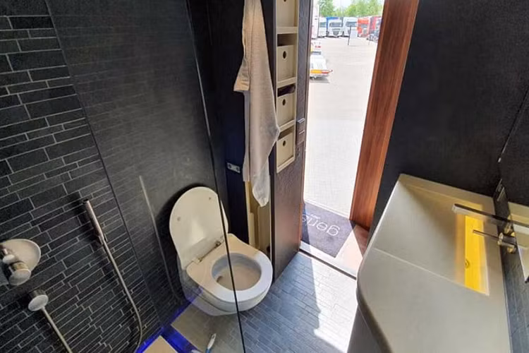 Mọi thứ còn trở nên xa hoa và hoành tráng hơn nữa khi nhìn vào không gian phía sau. Cụ thể, chiếc xe có lắp đặt buồng trượt kép lớn mà giúp mở rộng khu vực bếp và sinh hoạt, qua đó gia tăng đáng kể không gian nội thất. Nhờ thế, chiếc Scania này có sở hữu một nhà bếp đầy đủ tiện nghi với bếp từ 4 ô, một bồn rửa cỡ lớn kèm lò nướng, và một combo tủ lạnh/tủ đông dung tích 185 lít. Khu vực sinh hoạt có trang bị một ghế sofa lớn và một chiếc TV màn hình phẳng cỡ 32 inch – một trong ba chiéc TV trong xe.