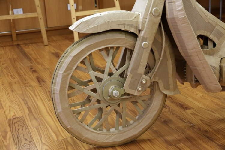 Nhóm 6 học sinh trung học và giáo viên hướng dẫn tạo nên chiếc Super Cub bằng bìa cứng. Để thực hiện dự án công phu này, các em học sinh đã phải học tập kỹ thuật lắp ráp bìa cứng từ cơ bản cho tới nâng cao trong suốt quá trình chế tạo, bao gồm cả việc làm bánh xe hoàn toàn bằng những chiếc hộp.