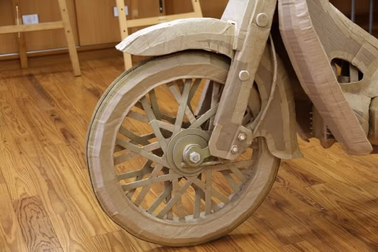 Nhóm 6 học sinh trung học và giáo viên hướng dẫn tạo nên chiếc Super Cub bằng bìa cứng. Để thực hiện dự án công phu này, các em học sinh đã phải học tập kỹ thuật lắp ráp bìa cứng từ cơ bản cho tới nâng cao trong suốt quá trình chế tạo, bao gồm cả việc làm bánh xe hoàn toàn bằng những chiếc hộp.