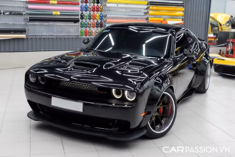 Điểm đặc biệt của mẫu xe cơ bắp Dodge Challenger “hàng hiếm” này nằm ở gói độ widebody cùng những món đồ chơi đắt giá được thực hiện bởi garage Việt Mỹ – một địa chỉ uy tín chuyên chăm sóc, bảo dưỡng và sửa chữa xe có tiếng ở khu vực quận 7, TP HCM. Tại Việt Nam, trào lưu độ widebody cho “xế cưng” không còn quá xa lạ với phần lớn những người chơi xe, điểm khó khăn nhất khi độ widebody (thân rộng) chính là làm sao cho thân xe trông thật hài hòa với bộ bodykit mới được bổ sung thêm chứ không chỉ đơn thuần làm tăng chiều ngang cho xe.
