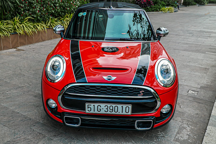 Thật ra màu sắc nguyên bản trên chiếc MINI Cooper S mui trần này là màu xanh ngọc. Tuy nhiên anh chủ xe đã quyết định thay đổi màu xanh này sang màu đỏ mới với những chi tiết dán decal khác.