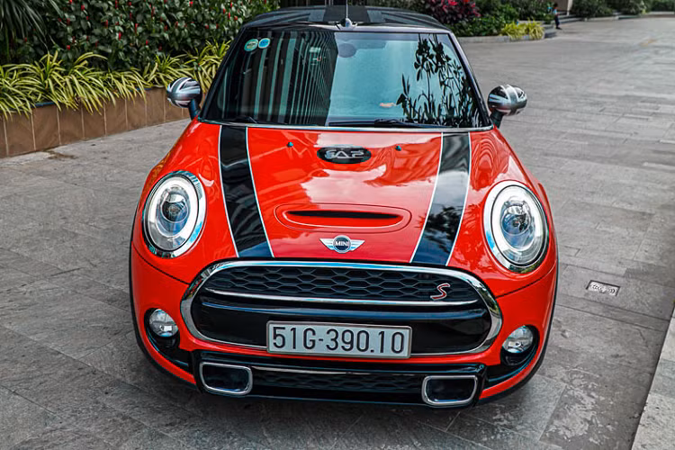 Thật ra màu sắc nguyên bản trên chiếc MINI Cooper S mui trần này là màu xanh ngọc. Tuy nhiên anh chủ xe đã quyết định thay đổi màu xanh này sang màu đỏ mới với những chi tiết dán decal khác.