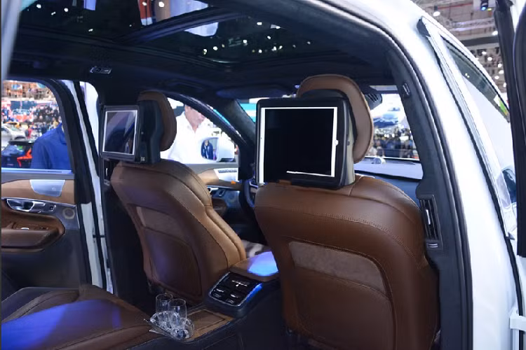 Khi đi đến bên hông xe từ hướng cửa tài, Volvo XC90 Excellence chẳng có gì nổi bật, vẫn là đèn hậu chạy dọc uốn lượn, dòng chữ XC90. Khác biệt của mẫu Volvo XC90 đắt nhất nằm ở logo T8 có thêm hình vương miện đặt kế bên. Đến đây có người sẽ hỏi vì sao Volvo XC90 Excellence lại có giá bán đắt đỏ đến thế? Sự tinh tế và đẳng cấp khiến XC90 Excellence bị đẩy giá bán cao gấp đôi một chiếc xe tiêu chuẩn nằm ở khoang lái. Cụ thể hơn là hàng ghế sau.