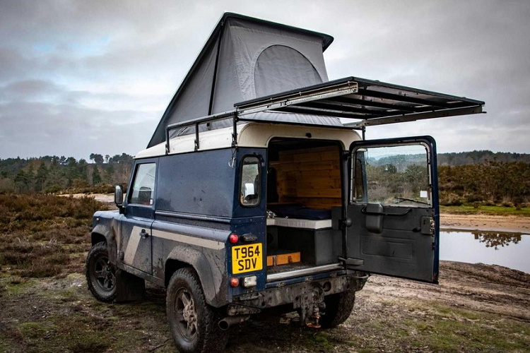 “Tôi chế tạo nó đơn giản vì tôi yêu thích đi khám phá! Tôi thích đi khỏi đường chính, tránh xa đám đông và các tuyến đường phổ thông”, Collier nói. Như chúng ta có thể thấy qua các bức ảnh, Collier đã biến chiếc xe Land Rover Defender off-road thành một phương tiện cắm trại nhỏ gọn, và khéo léo nhồi nhét nhiều tính năng tiện nghi vào không gian phía sau. Nội thất xe giờ đây được ốp gỗ gần như hoàn toàn và sử dụng hỗn hợp nhiều loại gỗ như thông, củ tùng cho mặt bàn và bảng sau, và Valchromat đen - một loại ván ép màu có khả năng chống ẩm và chống cháy.