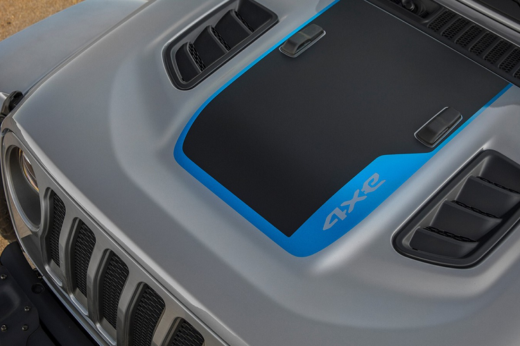 Những đặc điểm giúp phân biệt nhanh biến thể PHEV với model dùng động cơ xăng của Wrangler là các mảng màu xanh dương nổi bật xuất hiện ở ngoại thất. Chẳng hạn như tem trang trí nắp ca-pô, tên phiên bản dán trên đầu xe, logo Trail Rated bên hông xe, ký tự 4xe ở phía sau, móc kéo tời trước/sau và chi tiết hình xe Jeep trên la-zăng. Ngoài ra, vị trí cổng sạc pin được bố trí ở cột chữ A bên trái.