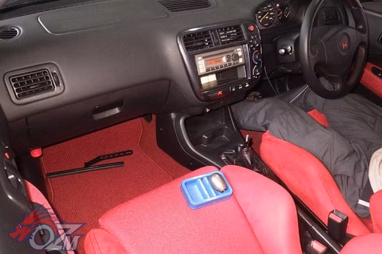 Cụ thể hơn, đây là một chiếc Honda Civic Type R đời 2000 và nó trông ngon lành đến độ ghế ngồi dường như chưa từng qua sử dụng. Hơn nữa, nó trông giống như một chiếc xe nguyên bản chưa từng độ, ngoại trừ lớp sơn màu đen che đi lớp sơn trắng ban đầu. Nội thất của xe trông vẫn còn mới, không hề có lấy một vết trầy, và nó cũng chỉ có chưa tới 2.600 km trên đồng hồ, tương đương chưa tới 130 km mỗi năm.