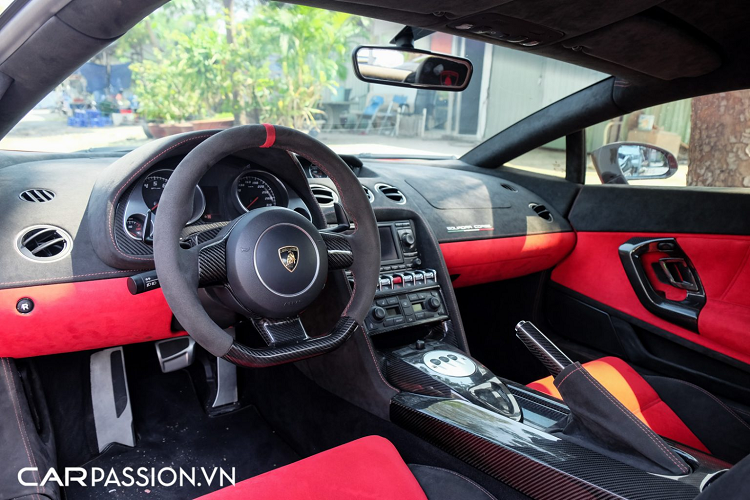 Tiến vào bên trong, xe sở hữu khoang lái phối hai màu đỏ-đen đầy thể thao, toàn bộ nội thất xe đều được bọc da Alcantara cao cấp và ốp sợi carbon. Cụ thể, các chi tiết như tay nắm cửa, vô-lăng, bảng đồng hồ, bệ tì tay hay phanh tay đều được ốp sợi carbon tương tự những chi tiết bên trong cabin của phiên bản Gallardo Squadra Corse. Vô-lăng xe có thiết kế 3 chấu đơn giản, tích hợp thêm lẫy chuyển số ở phía sau.