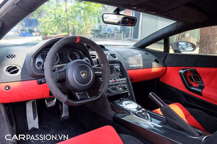 Tiến vào bên trong, xe sở hữu khoang lái phối hai màu đỏ-đen đầy thể thao, toàn bộ nội thất xe đều được bọc da Alcantara cao cấp và ốp sợi carbon. Cụ thể, các chi tiết như tay nắm cửa, vô-lăng, bảng đồng hồ, bệ tì tay hay phanh tay đều được ốp sợi carbon tương tự những chi tiết bên trong cabin của phiên bản Gallardo Squadra Corse. Vô-lăng xe có thiết kế 3 chấu đơn giản, tích hợp thêm lẫy chuyển số ở phía sau.