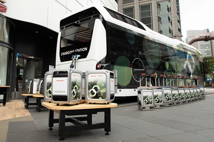Hệ thống “Moving e” gồm xe buýt chứa pin nhiên liệu của Toyota, thiết bị cấp điện di động Power Exporter 9000 của Honda, 2 khối pin di động cỡ lớn của Honda (LiB-AID E500 và Honda Mobile Power Pack) và bộ sạc đặc dụng.