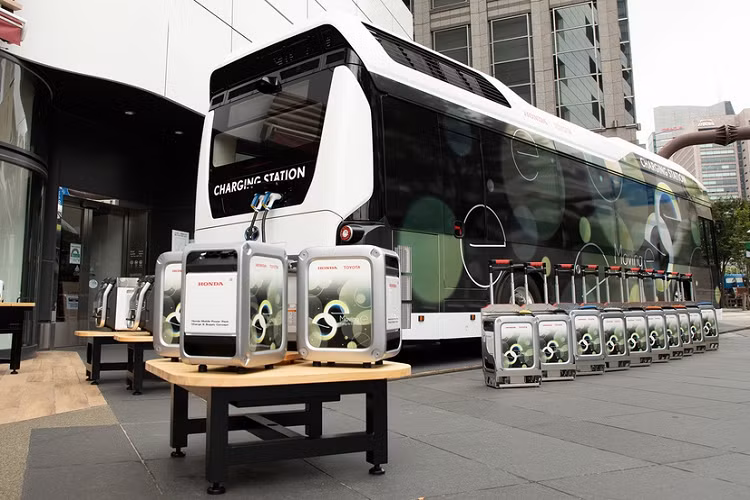 Hệ thống “Moving e” gồm xe buýt chứa pin nhiên liệu của Toyota, thiết bị cấp điện di động Power Exporter 9000 của Honda, 2 khối pin di động cỡ lớn của Honda (LiB-AID E500 và Honda Mobile Power Pack) và bộ sạc đặc dụng.