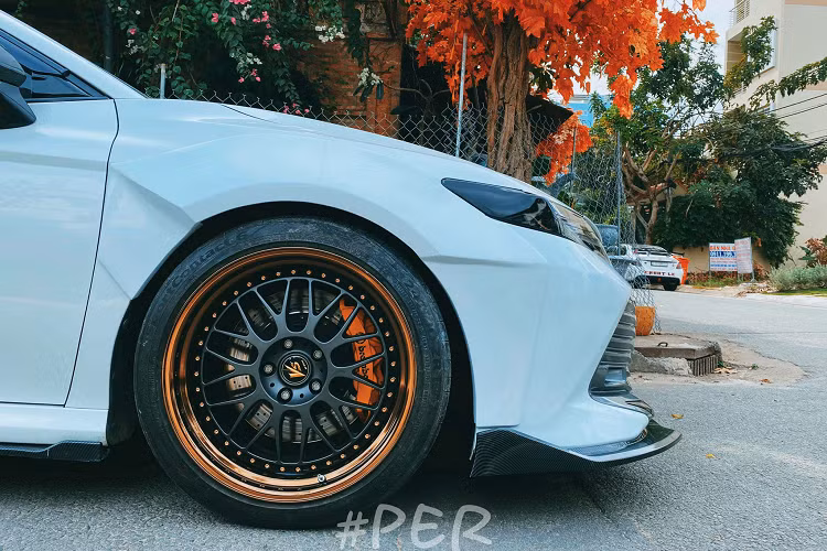 Mâm được chêm thêm các miếng spacers để ra ngoài hơn một tí nhằm phù hợp với thân rộng. Bộ mâm được sơn phối 2 màu tông đen vàng lạ mắt nổi bật với heo thắng màu cam. Dàn treo của xe hiện tại đang sử dụng phuộc đồ chơi. Chủ xe bật mí thêm, chiếc Camry hiện tại chỉ hoàn thiện được khoảng 80%. Trong thời gian sắp tới, anh sẽ nâng cấp hệ thống treo khí nén mới để có thể chủ động nâng và hạ gầm linh hoạt.