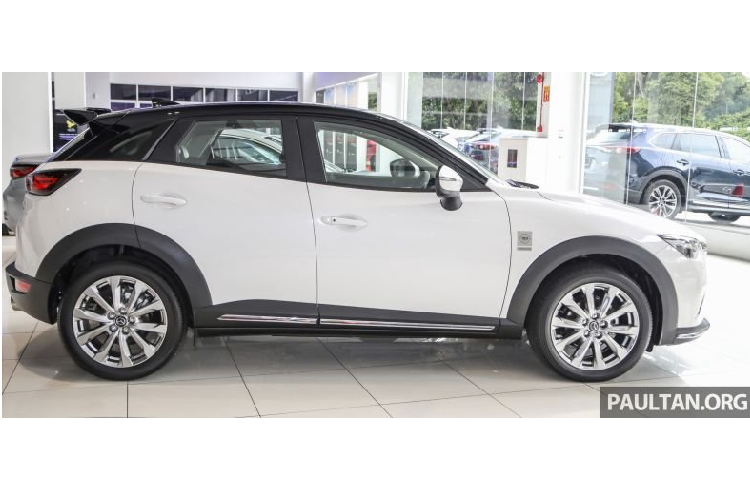 Tiến vào trong, phiên bản kỷ niệm Mazda CX-3 Limited Edition trang bị da lộn tông màu xám đậm cho ghế ngồi, vô lăng, tay vịn và cả cần số. Chất liệu này cũng được áp dụng cho trang trí bảng điều khiển và ốp trang trí cửa nhằm tăng cường độ sang trọng sẵn có của mẫu xe.