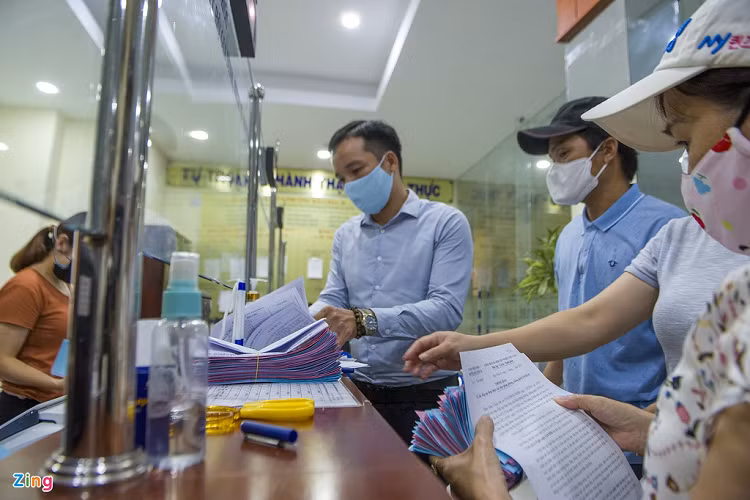 Đại diện ban quản lý tổ dân phố các phường, xã đến UBND quận Hải Châu nhận thẻ vào chợ, sau đó về phát cho người dân. 